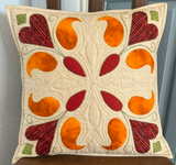 Hearts and Paisley appliqué cushion cover with orange paisley motifs, red hearts and green embroidery on cream quilted fabric.